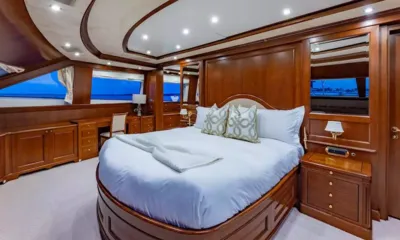Namaste: Cabine principal com grande cama de casal, painéis de madeira e escrivaninha junto às janelas