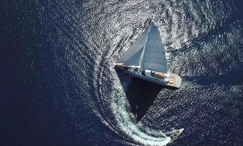 All About U 2: Overhead view of the yacht under sail with a tender carving a curved wake