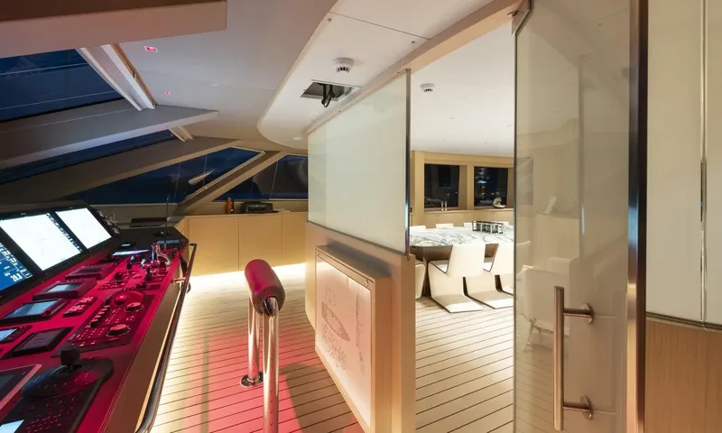 All About U 2: Helm station with illuminated screens and controls next to a glass door to the dining area