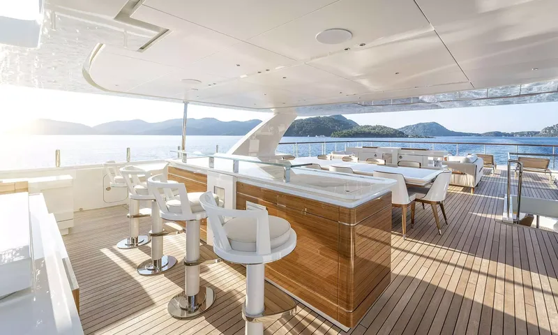 Sunrise: Shaded outdoor deck with bar stools, counter and dining table overlooking the sea