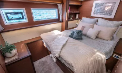 Liquid Zen: Cabine dupla com roupa de cama listrada, toalhas dobradas e janelas no casco voltadas para a água