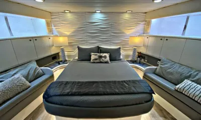 Runaway: Cabine com uma cama grande central, abajures de cabcabeceira, parede com textura de ondas e sofás laterais