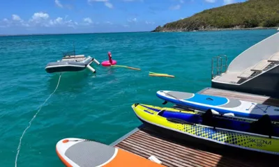 Seaclusion: スターンプラットフォームに置かれたパドルボードとカヤック、ターコイズ色の海に浮かぶテンダーとフラミンゴのフロート