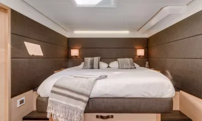 Ultra: Cabine com cama de casal, roupa de cama branca, manta listrada e paredes estofadas marrons