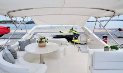 Flow: Flybridge sombreado com assentos curvos, mesa redonda e um jet ski guardado na popa