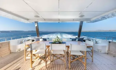 Ocean View: Mesa de jantar sombreada no deck de popa com cadeiras de diretor voltadas para a esteira e o mar