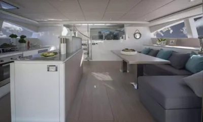 Moondance II: Salone principale con isola della cucina a sinistra e divano grigio accanto a un tavolo da pranzo