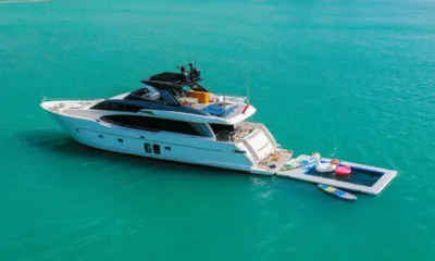 SL78: Iate ancorado em águas turquesa com piscina flutuante, boias e pranchas de stand up paddle na popa