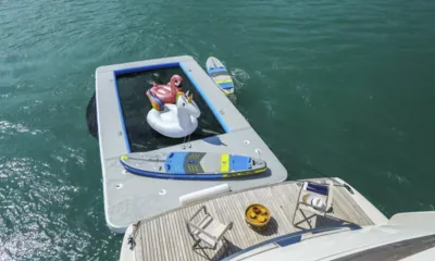 SL78: Piscina marinha flutuante com boias de flamingo e unicórnio e pranchas de stand up paddle atrás da plataforma de popa de teca