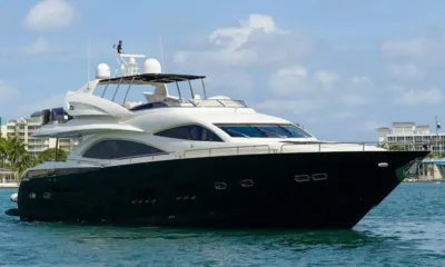 Catalana: Vista laterale dello yacht a motore che naviga davanti a edifici sul lungomare sotto un cielo azzurro