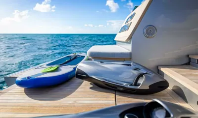 Bad Mutha: Prancha de stand up paddle inflável e scooter subaquático sobre um deck de popa de teca junto ao mar