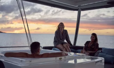 La Gatta: Convidados conversam ao lado de um jacuzzi no convés superior sob um pôr do sol colorido