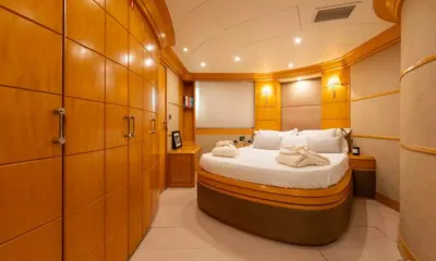 Lady B: Cabine com cama de casal, roupões dobrados, armários de madeira e iluminação aconchegante