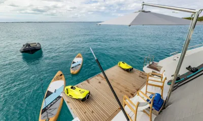 Pier Pressure: Piattaforma di poppa con scooter subacquei, tavole da SUP e un tender che galleggia vicino