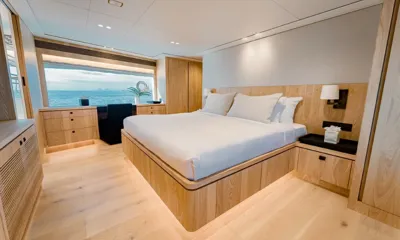 Sea-Renity: Cabin with large white bed, oak joinery and a wide window onto the sea
