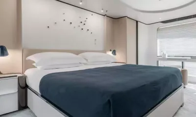 Double Trouble: Cabine com cama de casal grande, manta azul-marinho, abajures de cabeceira e uma escrivaninha junto à janela