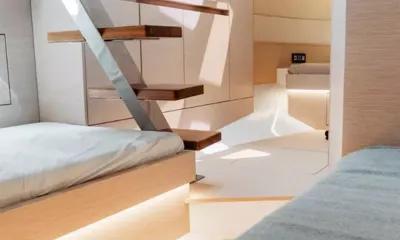 Maverik: Cabine de madeira clara com camas de cada lado de uma escada de madeira flutuante