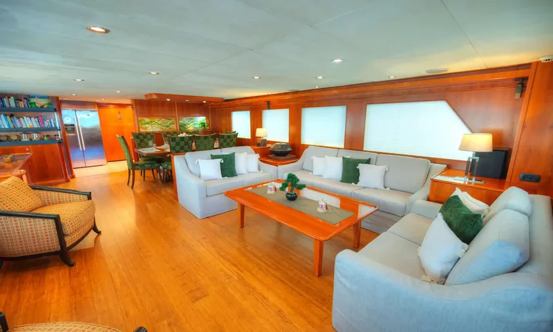 Voyager: Wood panelled saloon with light sofas, coffee table and dining area behind