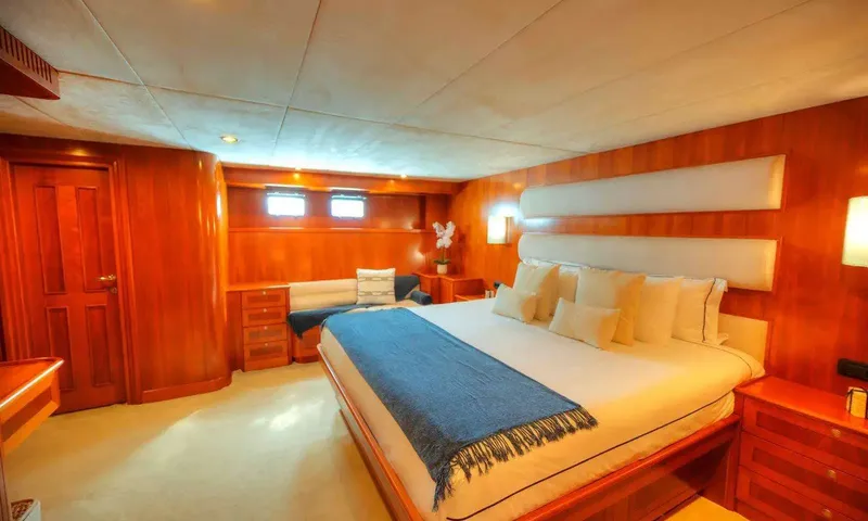 Voyager: Cabin with large double bed, blue throw, wood panelling and small windows