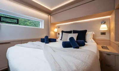 Siete Mares: Cabine com uma grande cama branca, toalhas azul-marinho, luminárias de leitura e uma janela comprida