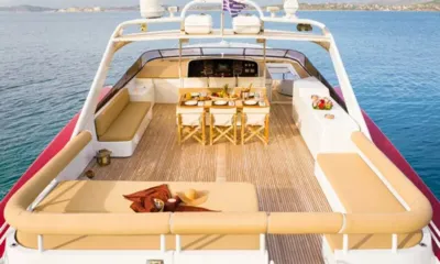 Elegant: Deck de popa aberto com colchonete de sol, assentos laterais e mesa de jantar em direção ao leme