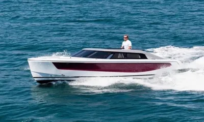 Quinta Essentia: Bote auxiliar branco e bordô em alta velocidade pelo mar com um condutor ao leme