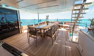 Fifi I: Mesa de jantar do deck de popa com cadeiras e um lounge ao fundo, com vista para uma baía com barcos