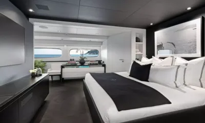 Impulsive: Cabin with large white bed, black throw, framed photograph and sea view windows