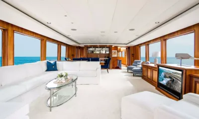 Silver Seas: 白いソファ、ガラスのコーヒーテーブル、木製パネル、大きな海側の窓を備えた明るいサロン