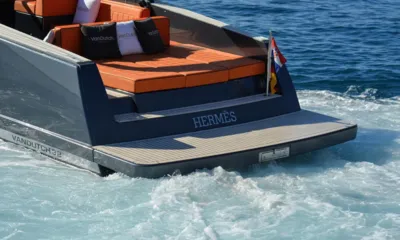 Hermes: 荒れ立つ航跡の上にオレンジのサンパッド、クッション、チークのスイムプラットフォームを備えた船尾