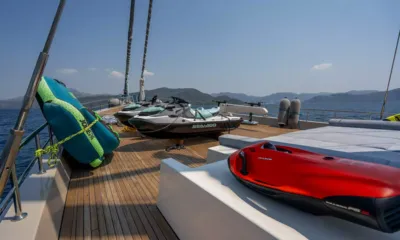 De Love: Jet skis, a towable tube and a red underwater scooter on the teak deck