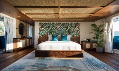 King Benji: Spacious cabin with large bed, tropical leaf wall, palm plant and woven ceiling