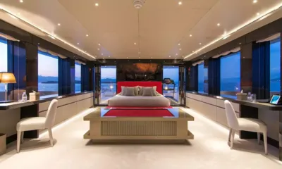 My Eden: Cabine ampla com cama central, cabeceira vermelha, escrivaninhas dos dois lados e vista para o mar