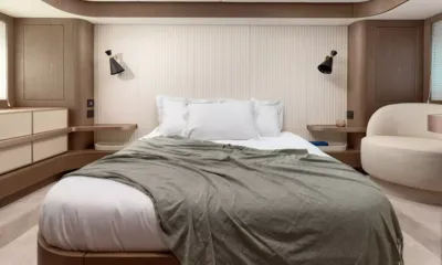Princess M: Cabine com cama de casal, manta cinza, luminárias de parede e uma poltrona creme
