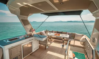 Scenery: Shaded flybridge with wet bar, grill, fridge and dining table facing the sea