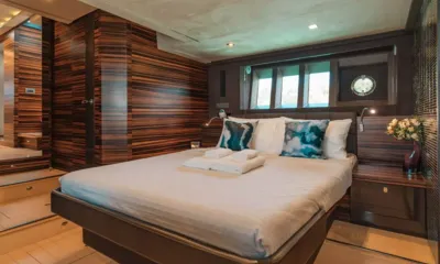 Scenery: Double cabin with striped wood panelling, patterned cushions, folded towels and flowers by the window