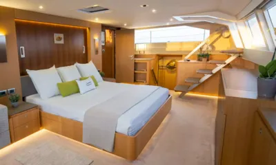 NDS Evolution: Spacious cabin with large double bed, warm wood panelling and a small staircase