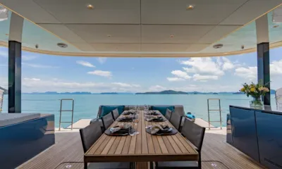 E Motion: Aft deck dining table set for eight facing open sea and distant islands