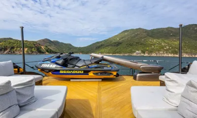 Rock: Jet ski stored on a teak deck beside a launching crane, hills behind