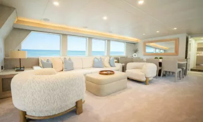 Shorething: Salão com sofá creme, poltronas fofas, pufe e área de jantar ao lado de janelas com vista para o oceano