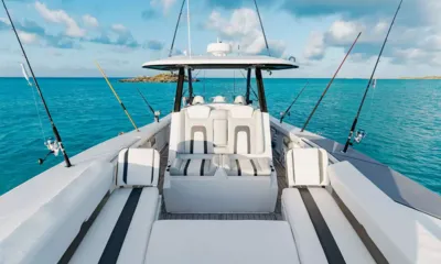 Odyssea: Cockpit do bote auxiliar com assentos brancos e várias varas de pesca, mar turquesa ao redor