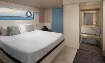 Aglaya: Cabina con letto matrimoniale, finestra con vista mare, armadio blu e bagno privato aperto