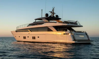 Vauban: Side view of a white motor yacht cruising on open sea in warm sunset light