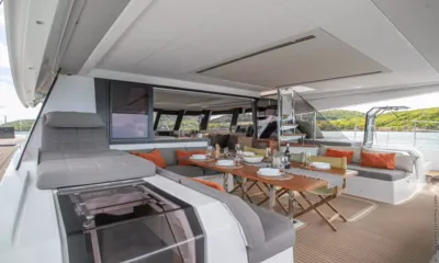 Okinawa: Covered aft deck with set dining table, grey sofas and orange cushions