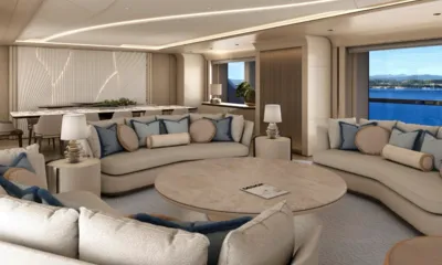 O'Madeleine: Lounge com sofás curvos, almofadas azuis e mesa redonda ao lado de grandes janelas com vista para o mar