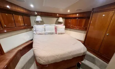 B74: Cabine com cama de casal, travesseiros estampados, luminárias de leitura e armários de madeira brilhante