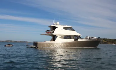 Wasting Light: Iate a motor ancorado em águas calmas sob céu azul com um jet ski por perto