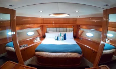 Hecht Yeah: Cabine com cama de casal, manta azul, painéis de madeira brilhantes e vigias