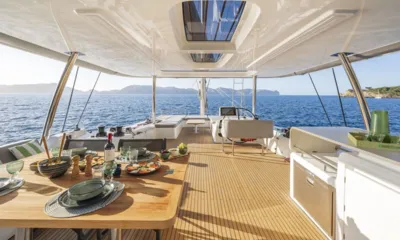 Lady M: Mesa do flybridge posta com comida e bebidas, leme e mar aberto ao fundo