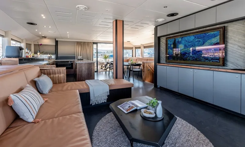 Hani I: Saloon with tan leather sofa, dark coffee table, framed artwork screen and dining area beyond